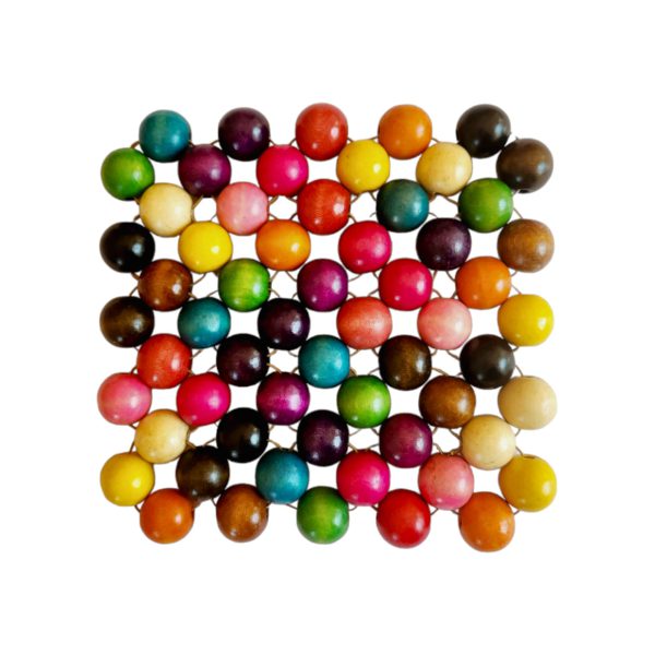 Firkantet gryteunderlag av treperler i mange farger, snørt sammen med snor, mot hvit bakgrunn.